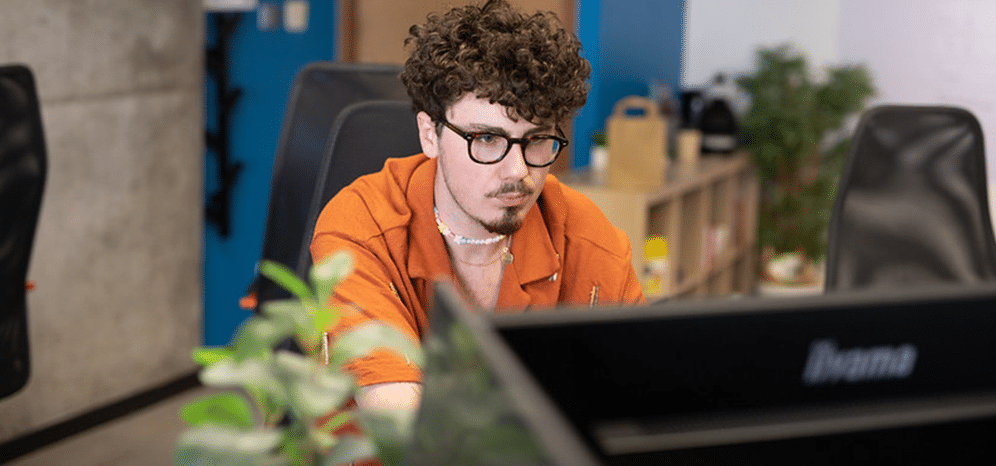 Une personne travaille sur un ordinateur dans un espace de bureau.